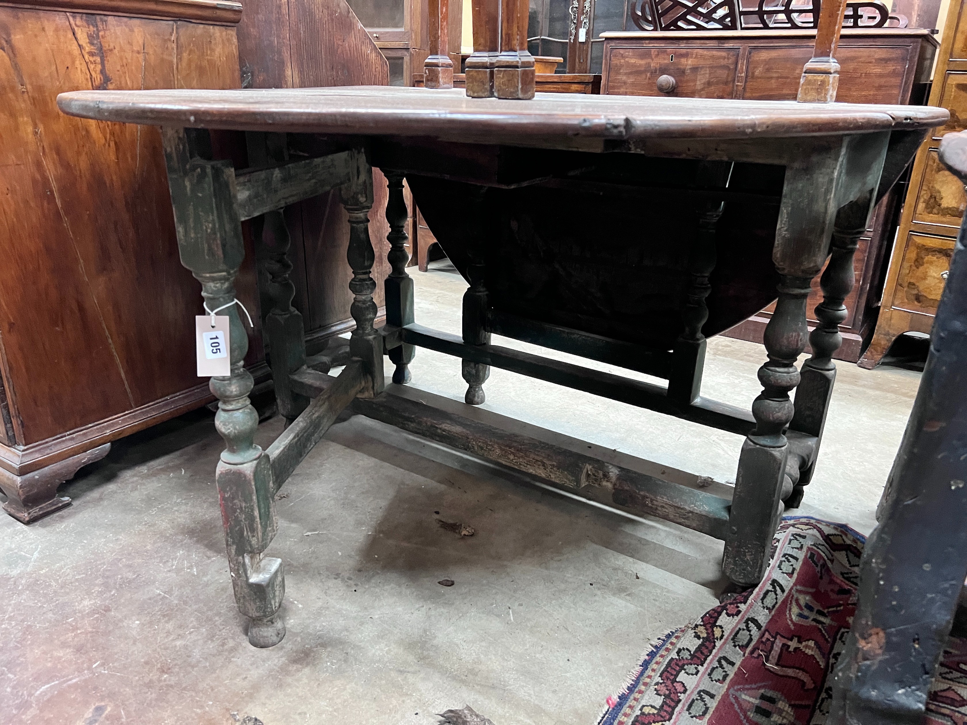 An 18th century oak gateleg dining table, the turned underframe with traces of old paint, length 123cm, depth extended 134cm, height 72cm *Please note the sale commences at 9am.
